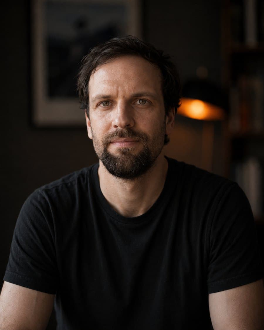 Jonas Himbert, Gründer von Hidane, im dunklen Raum mit warmem Lampenlicht